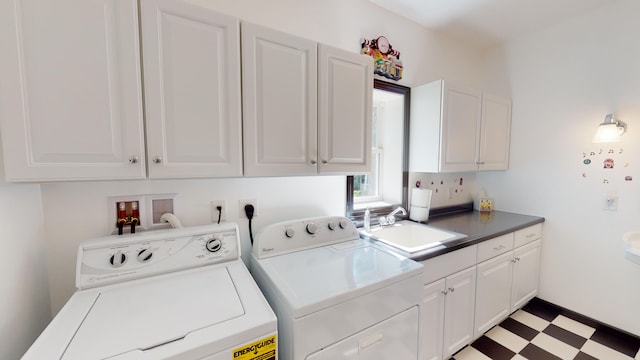 laundry area featuring cabinet space, light floors, independent washer and dryer, and a sink