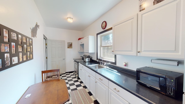 kitchen with tile patterned floors, stainless steel range with electric stovetop, a sink, dark countertops, and black microwave