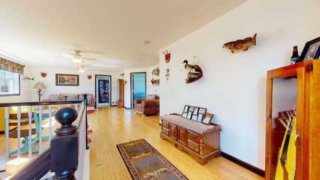 interior space with light wood-style flooring, an upstairs landing, and baseboards