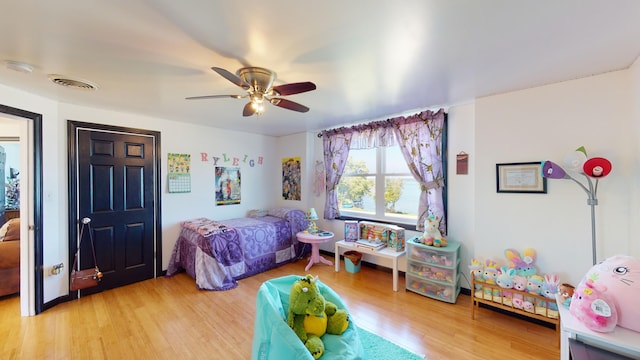 bedroom with a ceiling fan, light wood-style floors, and visible vents