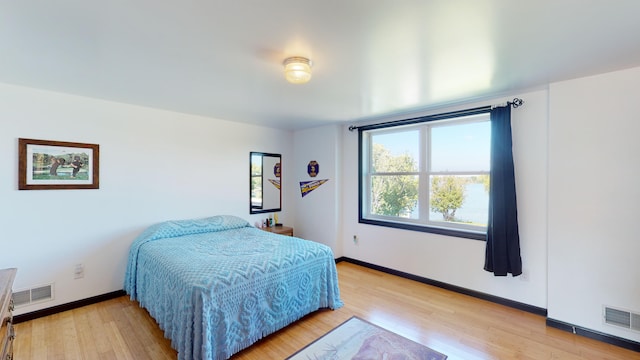 bedroom featuring baseboards, visible vents, and light wood-type flooring