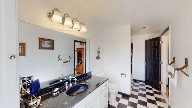 bathroom with tile patterned floors, visible vents, toilet, and vanity