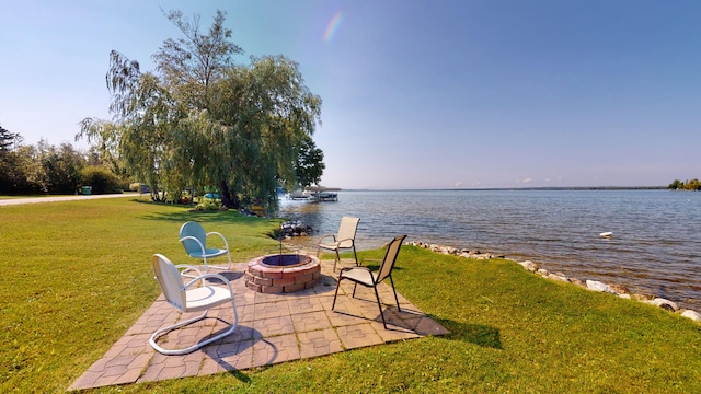 view of yard with a patio area, a water view, and a fire pit