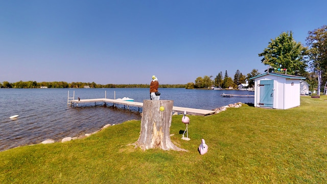 dock area with a water view and a lawn