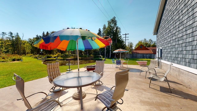 view of patio with outdoor dining space, a fire pit, and fence