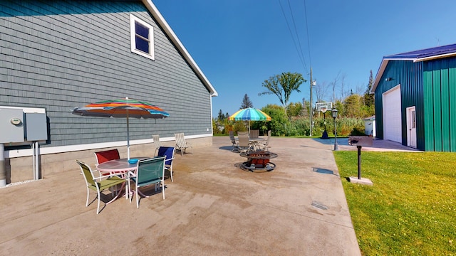 view of patio / terrace with an outdoor fire pit, outdoor dining area, and an outdoor structure