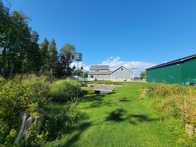 view of yard featuring an outdoor structure and a pole building