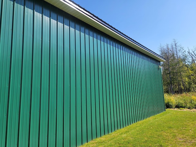 view of home's exterior with an outbuilding and a yard