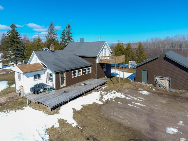 back of house featuring a wooden deck and a chimney