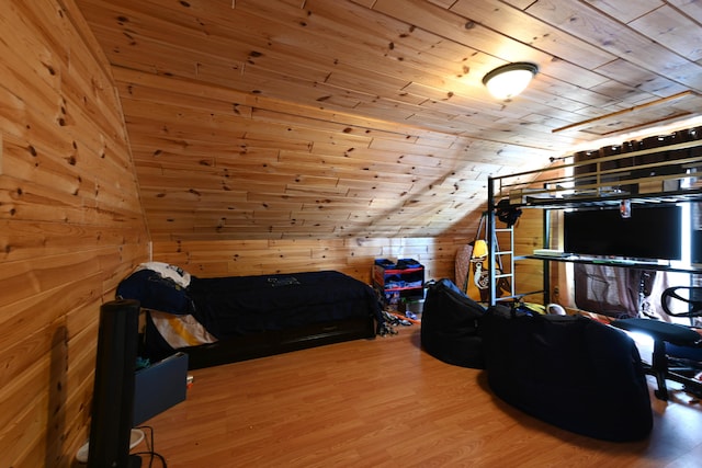 bedroom with wood finished floors, lofted ceiling, wood ceiling, and wood walls