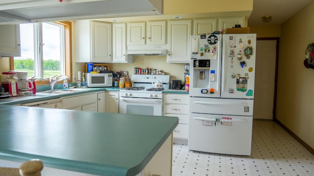 kitchen with under cabinet range hood, a sink, white cabinetry, white appliances, and light floors