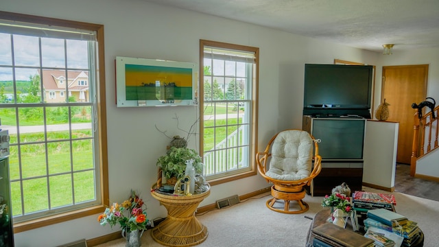 sitting room with carpet flooring, visible vents, and baseboards