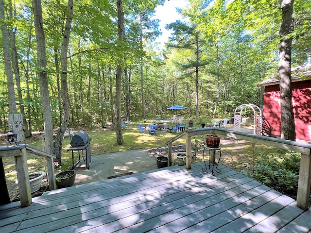 wooden deck featuring area for grilling and an outdoor fire pit