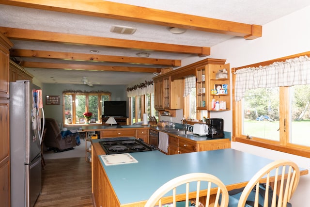 kitchen featuring open shelves, stovetop, beam ceiling, freestanding refrigerator, and dark wood-style flooring