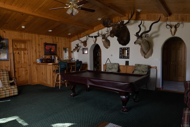 rec room with a ceiling fan, arched walkways, carpet floors, wooden ceiling, and a dry bar