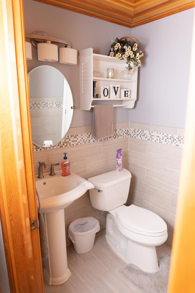 half bathroom featuring toilet, tile walls, and tile patterned flooring