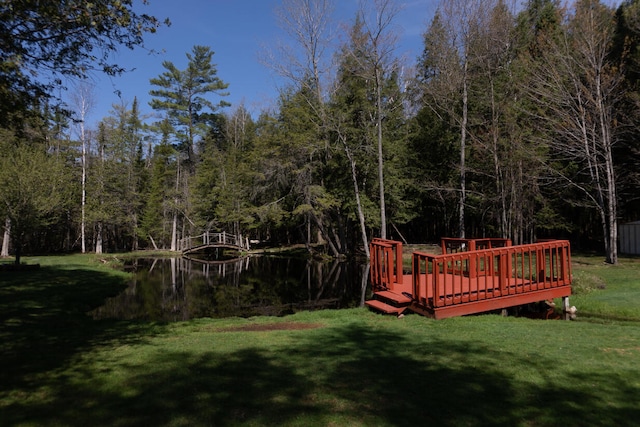 view of yard with a wooden deck and a forest view