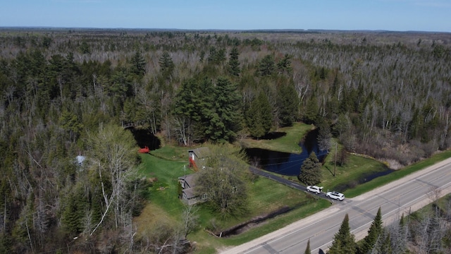 drone / aerial view featuring a wooded view