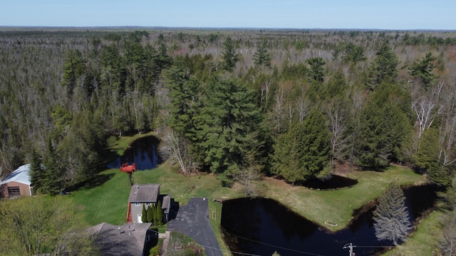 birds eye view of property featuring a forest view and a water view