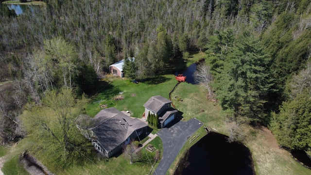 birds eye view of property with a wooded view and a water view