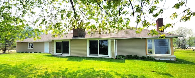 rear view of house with a lawn and a chimney