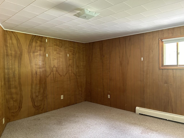 empty room with a baseboard radiator, carpet floors, and wood walls