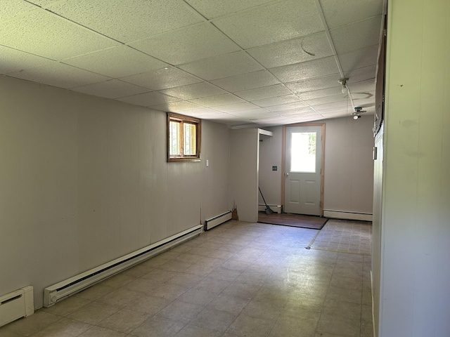 below grade area featuring baseboard heating, a healthy amount of sunlight, and a baseboard radiator