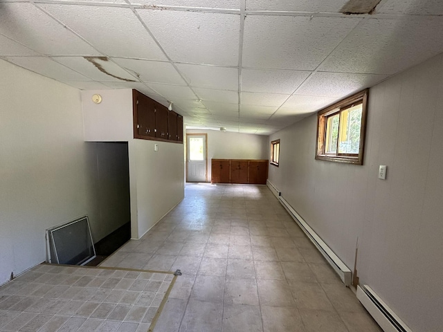 interior space featuring a baseboard heating unit, a drop ceiling, and baseboard heating