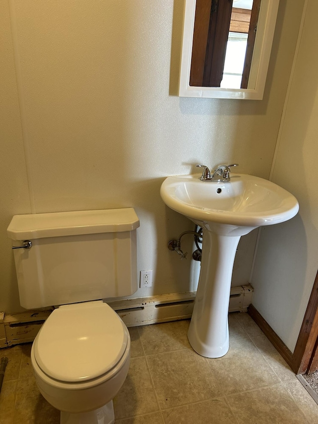 bathroom featuring tile patterned floors, a baseboard heating unit, baseboards, and toilet