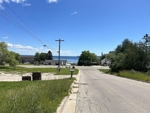 view of road with curbs and a water view