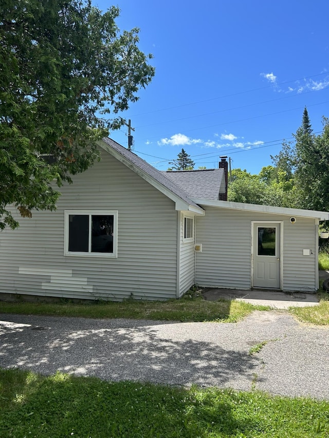 rear view of property featuring a chimney