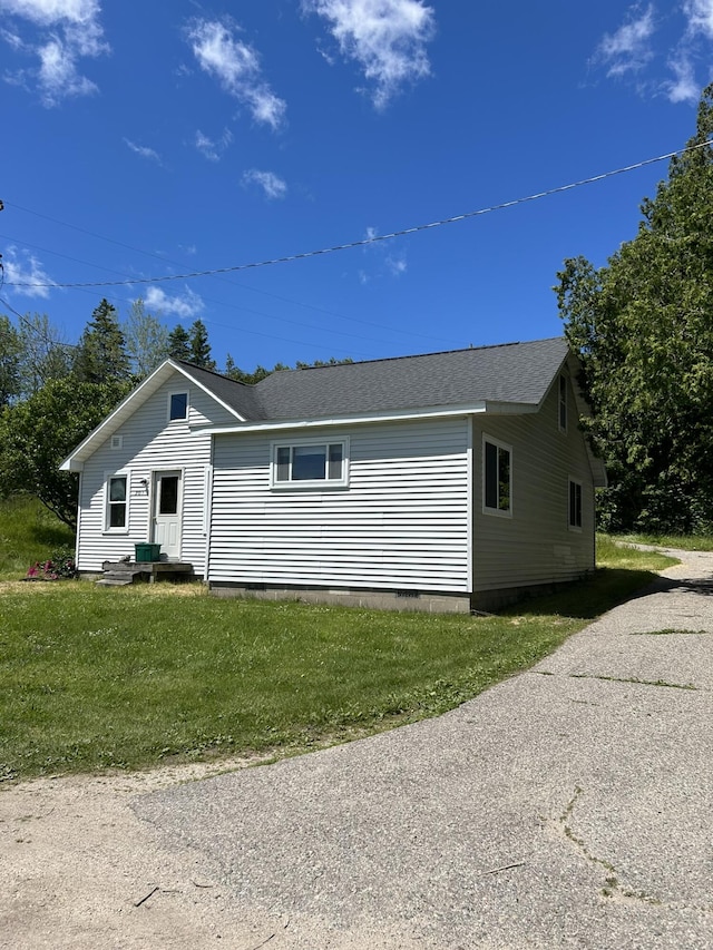 view of front facade featuring crawl space, roof with shingles, and a front yard