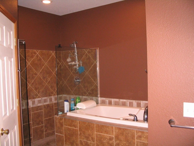 full bathroom with a garden tub and a tile shower