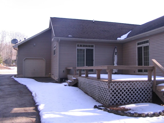 snow covered rear of property featuring a deck