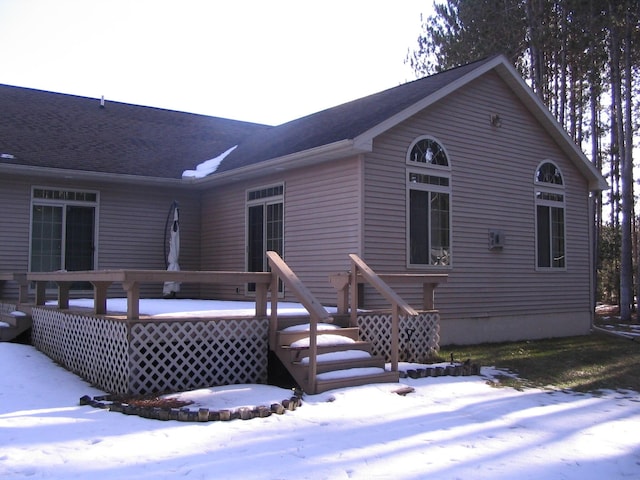 snow covered house with a deck