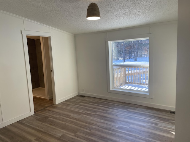 unfurnished room with vaulted ceiling, baseboards, dark wood-style flooring, and a textured ceiling