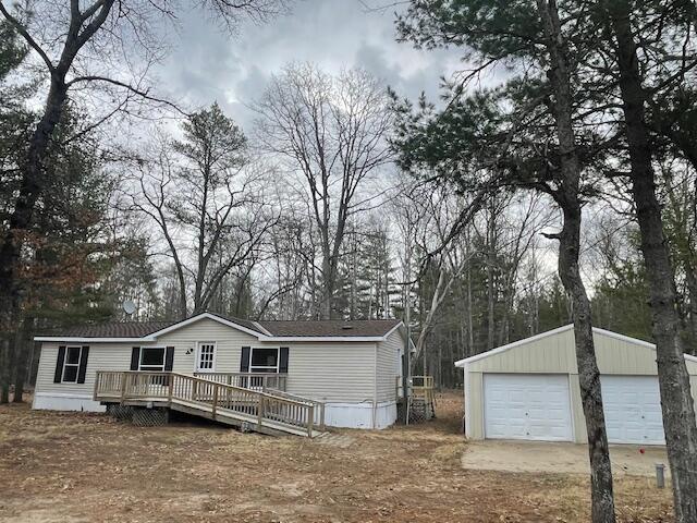 manufactured / mobile home with an outbuilding, a garage, and a wooden deck