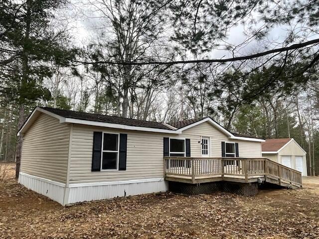 view of front of property featuring an outdoor structure, a detached garage, and a wooden deck