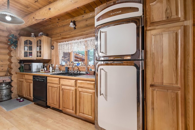 kitchen featuring a sink, stainless steel microwave, refrigerator, rustic walls, and dishwasher