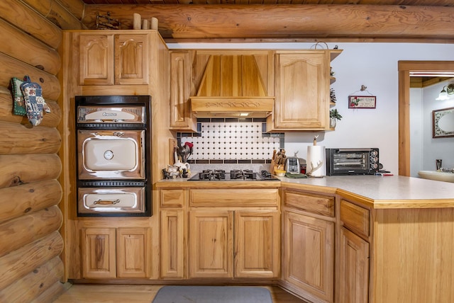 kitchen featuring custom range hood, gas stovetop, light wood finished floors, log walls, and light countertops