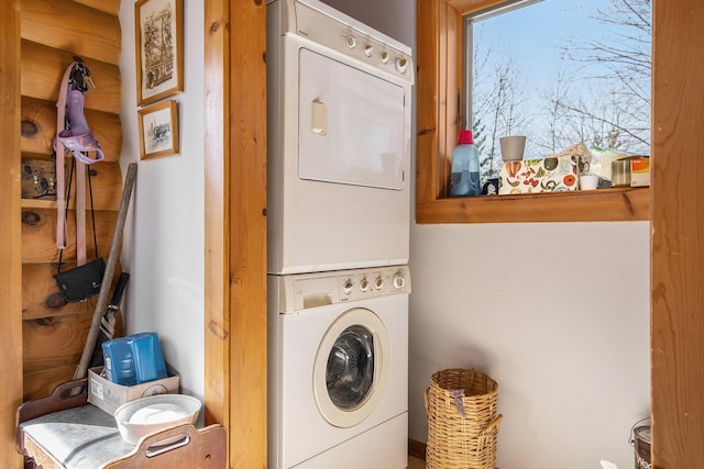 washroom featuring stacked washer / drying machine and laundry area