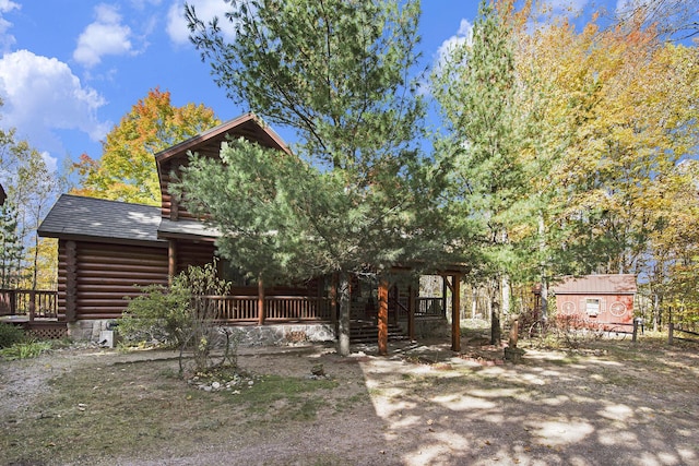 back of house featuring log siding and a porch