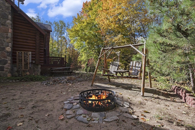 view of yard with a wooden deck and an outdoor fire pit