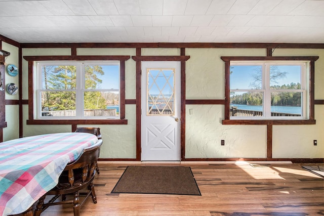 dining room featuring baseboards, wood finished floors, and a textured wall