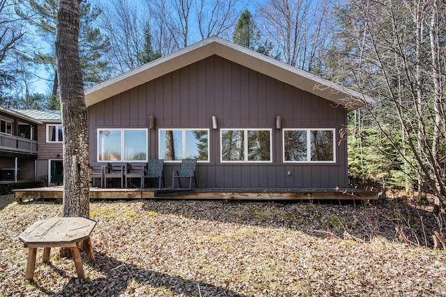 back of house featuring a deck and metal roof