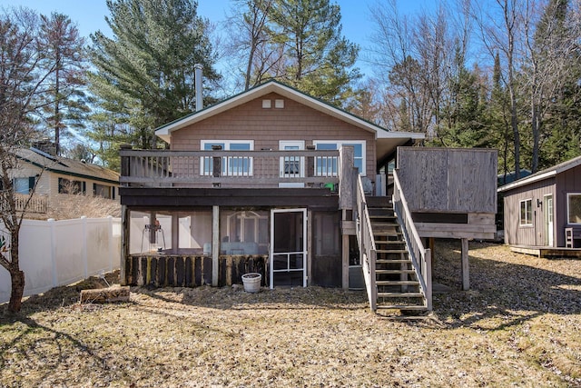 rear view of property featuring stairway, fence, a sunroom, and a wooden deck