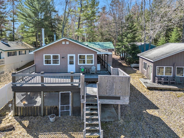 back of property with stairs, fence, and a wooden deck