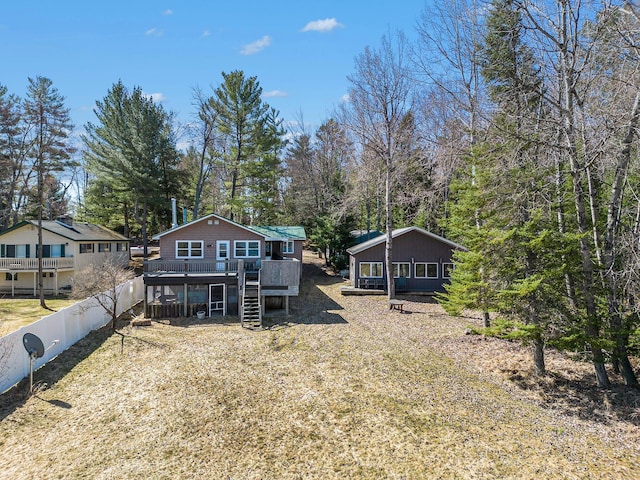 back of property with a deck, stairs, and fence