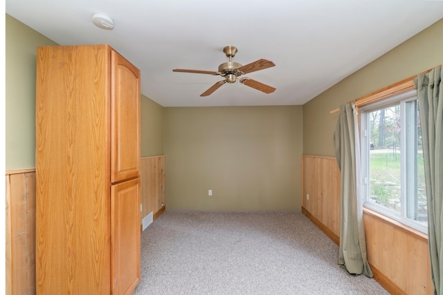 9219 Tall Birch, Gaylord, MI 49735 - unfurnished room featuring wainscoting, ceiling fan, light carpet, a smoke detector, and wood walls