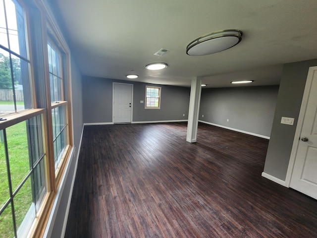 below grade area with wood finished floors, visible vents, and baseboards